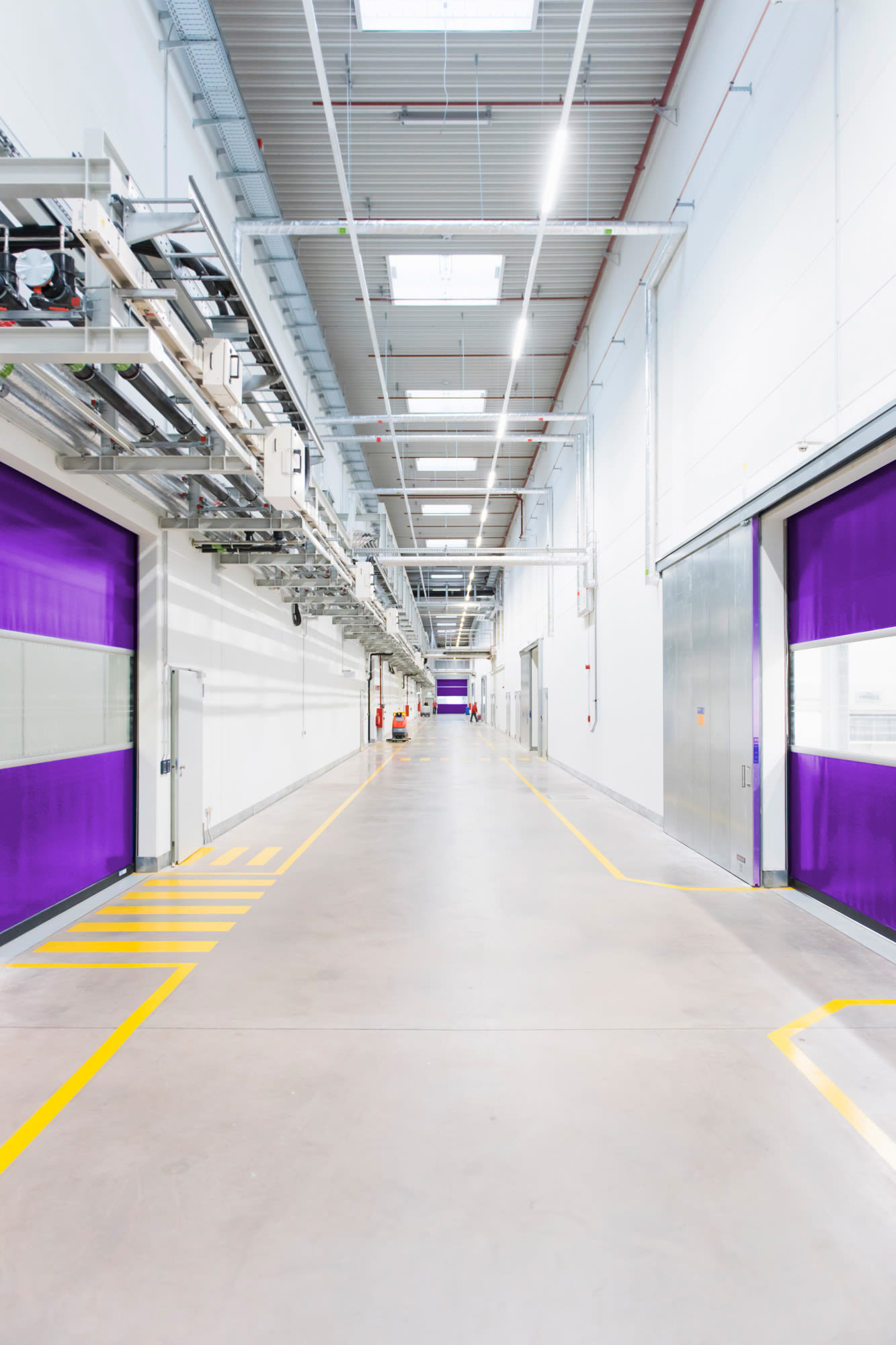 Moderan industrijski hodnik s ljubičastim vratima – infrastrukturna rješenja usmjerena na budućnost kod BKS Banke.