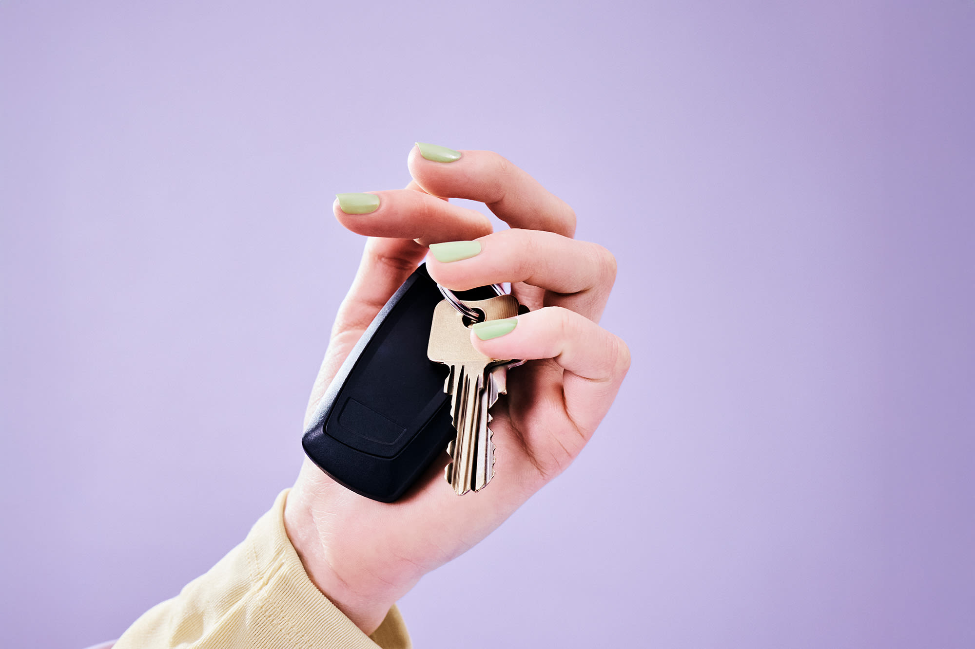  Ruka s ključevima automobila ispred ljubičaste pozadine – leasing vozila s BKS Bankom: fleksibilno i jednostavno.