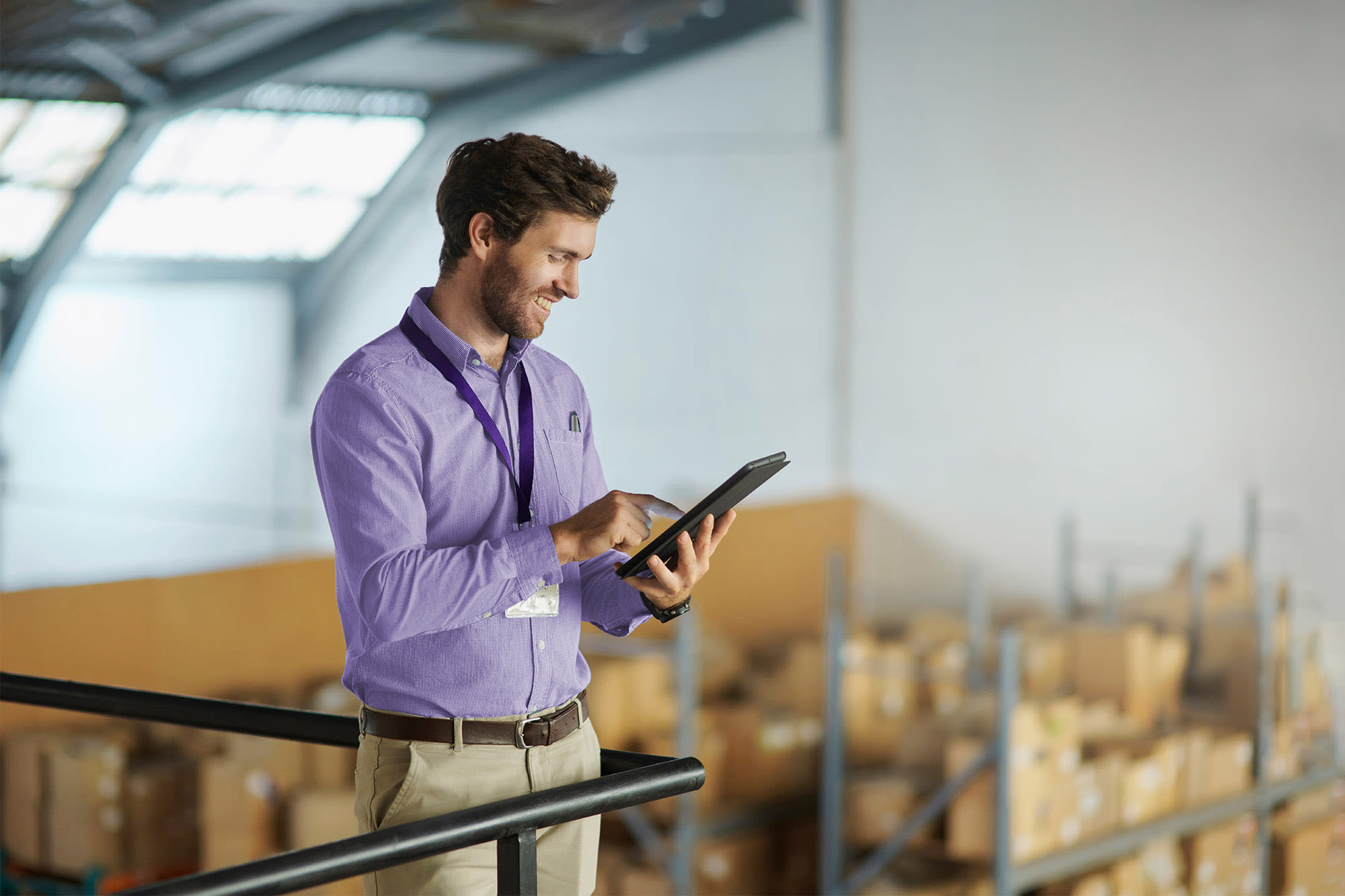 Pracovník skladu používa tablet - digitálne procesy pri obchodovaní s firemnými zákazníkmi.
