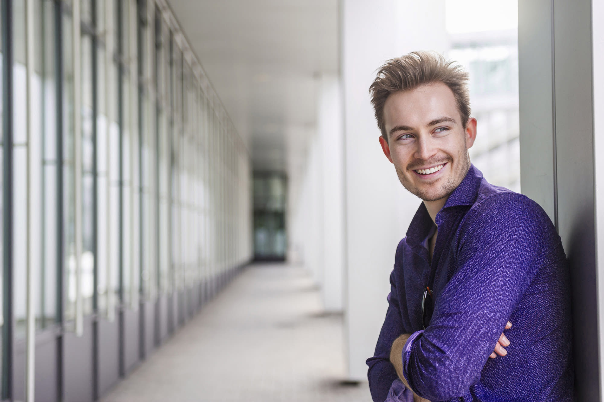 Muškarac u ljubičastoj košulji smiješi se u poslovnom okruženju – individualna rješenja za korporativne klijente BKS Banke.