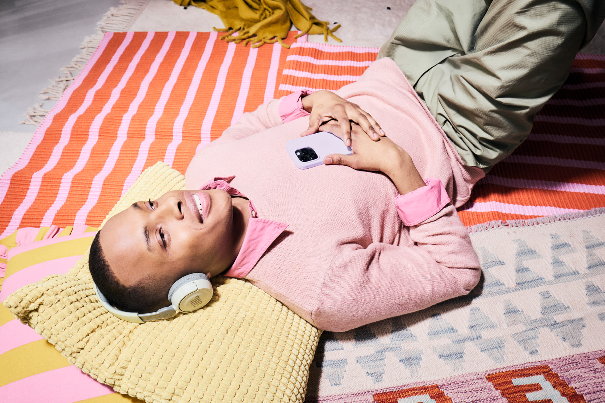 Mlada osoba s pametnim telefonom leži na podu – udobno ulaganje s Komfort-depom BKS Banke. Mlada osoba s pametnim telefonom leži na podu – udobno ulaganje s Komfort-depom BKS Banke.