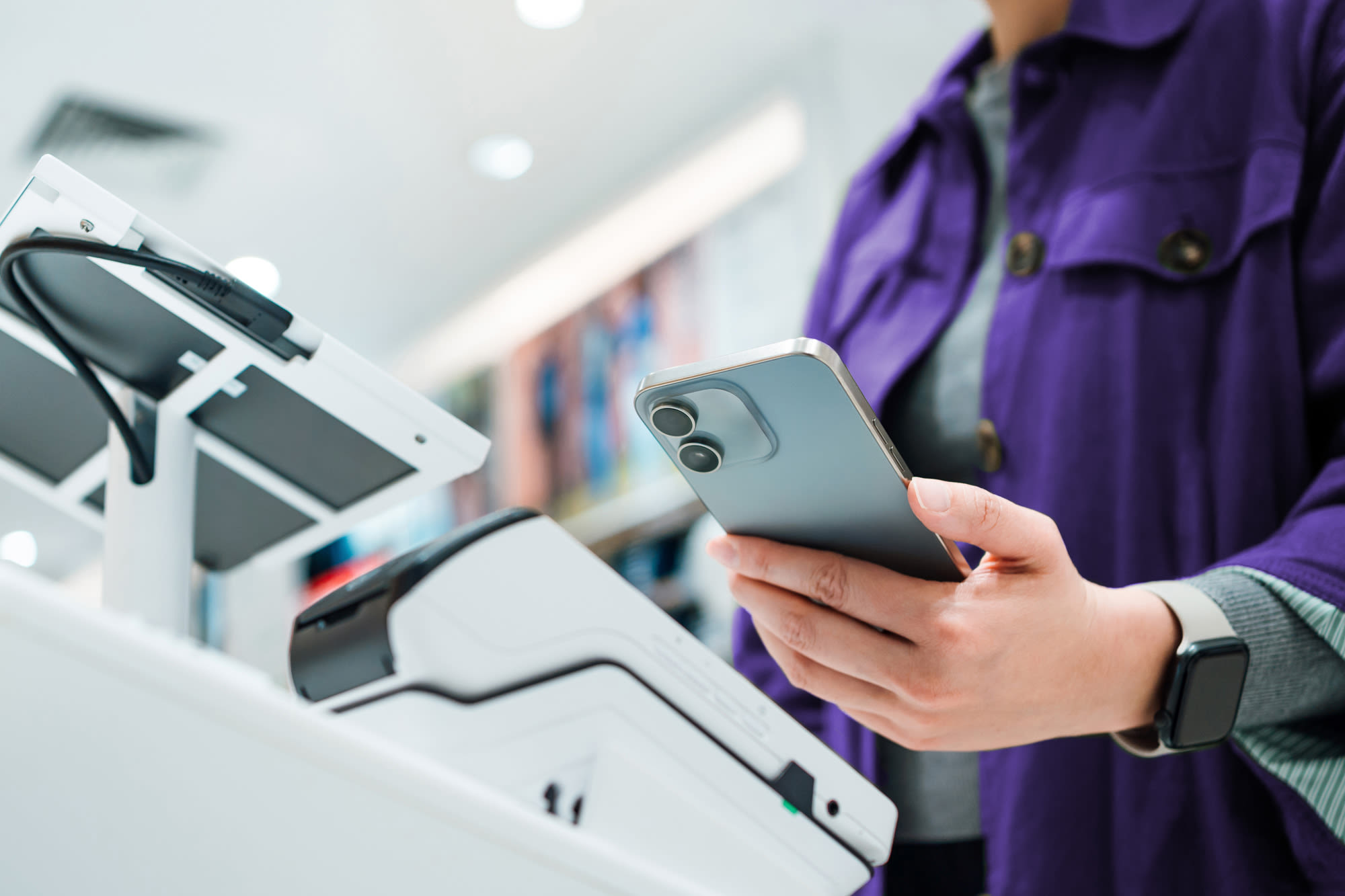 Klijentica plaća beskontaktno pametnim telefonom. Klijentica plaća beskontaktno pametnim telefonom.